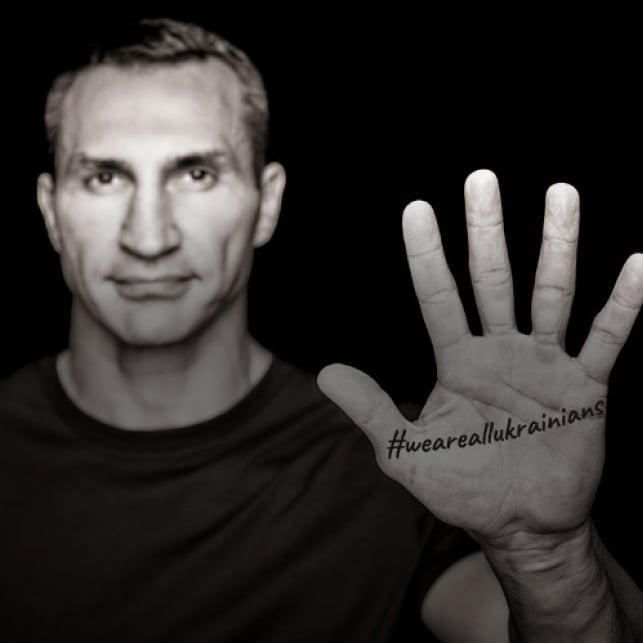 Ein Mann zeigt seine Handfläche in die Kamera. Die Handfläche hat den Tag #WeAreAllUkrainians