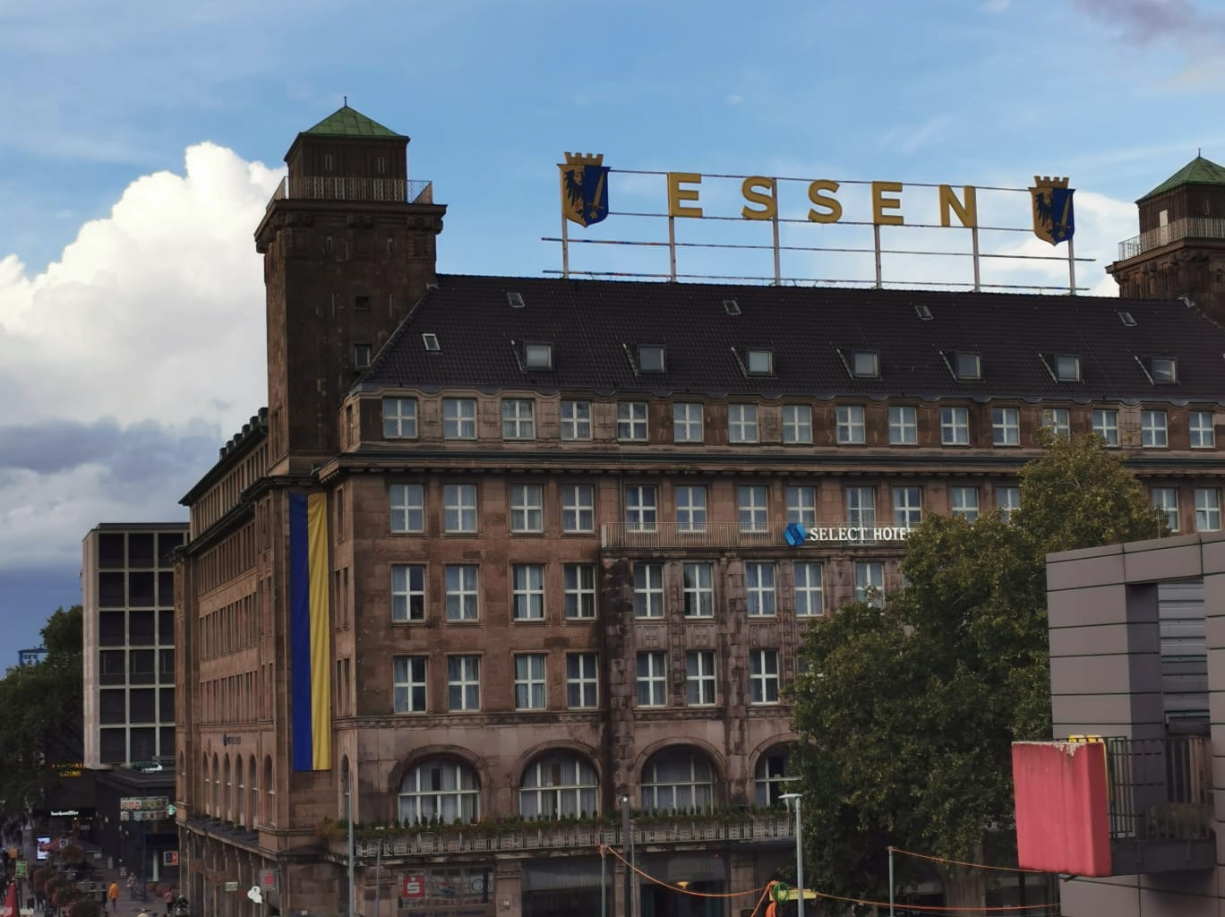 The historic Hotel Handelshof building in Essen, Germany, featuring a large 'ESSEN' sign on the roof and two corner towers