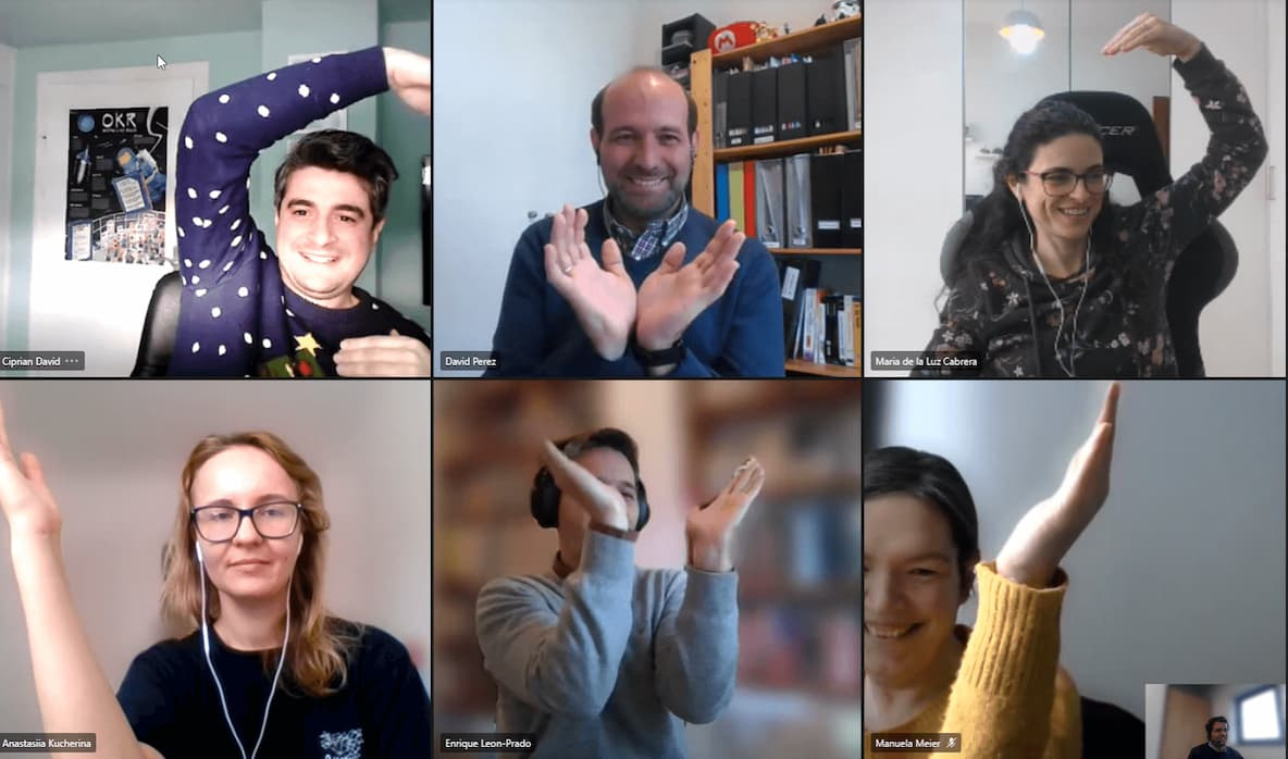 Cocomore team members attempting to make a heart with their arms in a videocall