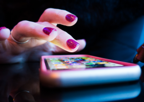 woman with nailpolish using her phone