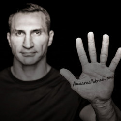 Ein Mann zeigt seine Handfläche in die Kamera. Die Handfläche hat den Tag #WeAreAllUkrainians